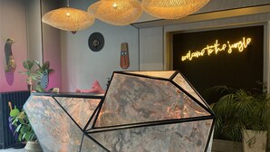 A geometric, marble-patterned reception desk with a neon sign reading "welcome to the jungle" in the background. - Urban Jungle. Hotel Orléans (Orléans)