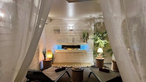 Un espace de repas accueillant et moderne, doté d’une cheminée, de sièges confortables et de plantes décoratives.