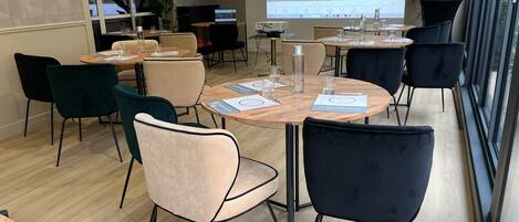 A conference room with round tables, chairs, and a projection screen displaying a webpage.