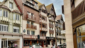 Un hôtel européen traditionnel, avec plusieurs étages, des balcons et une enseigne indiquant « Hôtel Le Trophée ».