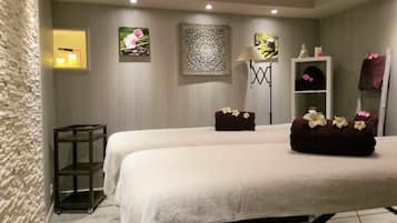 Comfortable room with two beds, a floor lamp, and a shelf unit, perfect for relaxation.