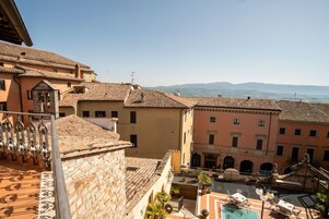 Un cortile con piscina, circondato da edifici tradizionali con tetti in terracotta e pareti in pietra.