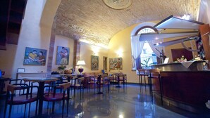Un restaurant aux murs en briques, agrémenté de tableaux et doté d’un espace bar.