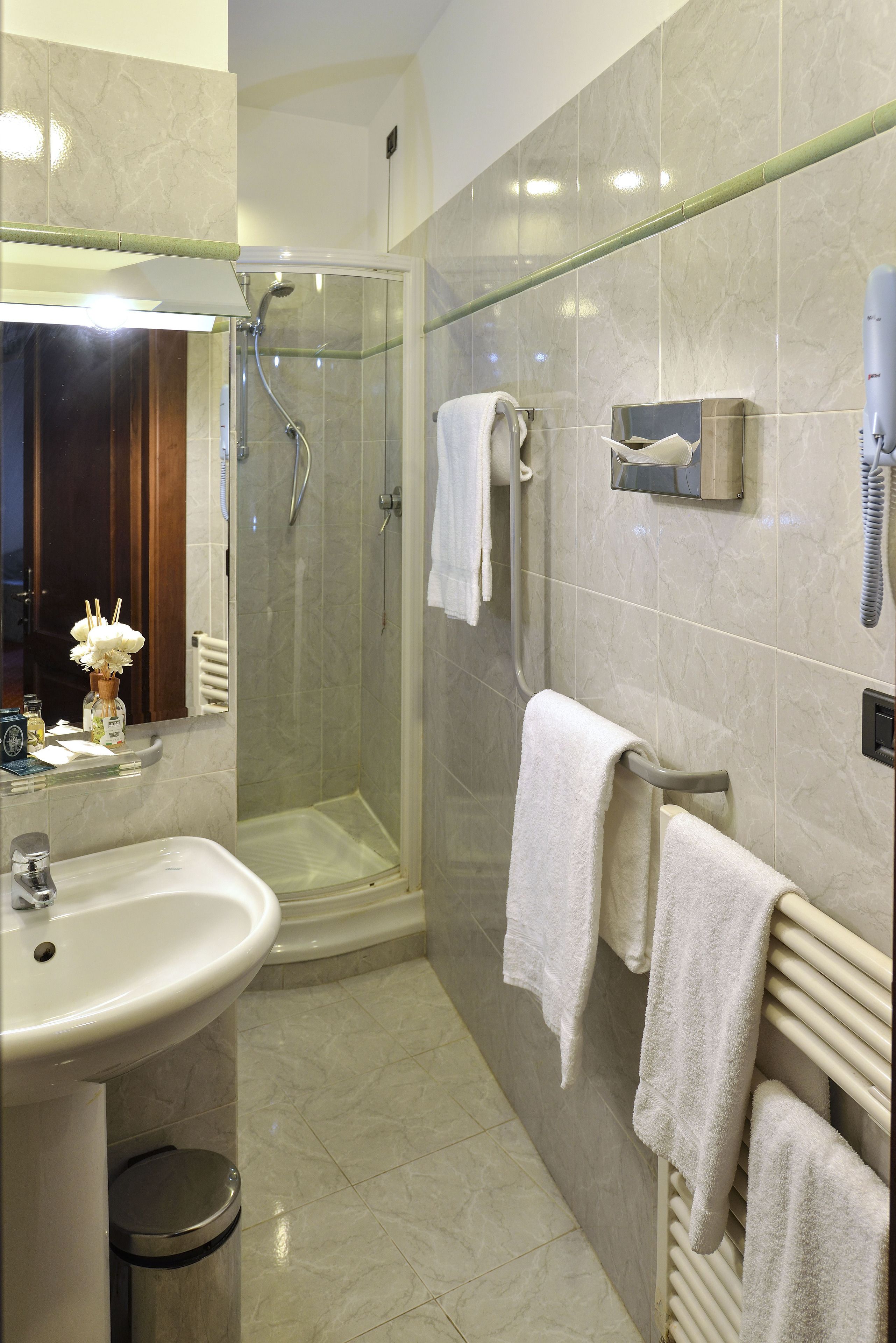A modern bathroom with a glass-enclosed shower, a sink, and a towel rack.