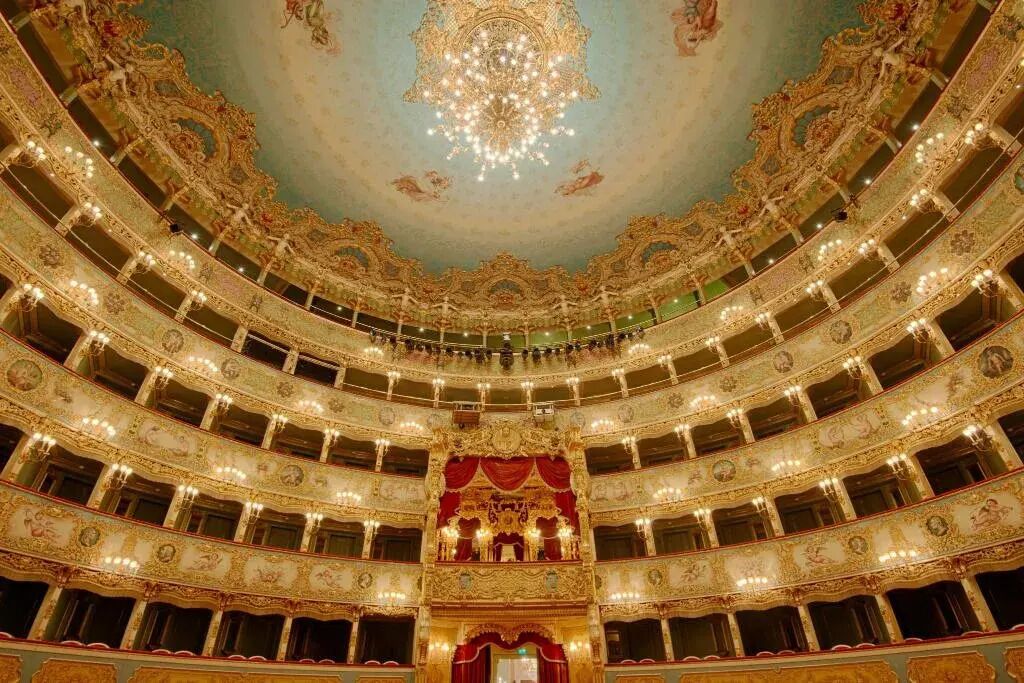A multi-tiered theater with ornate golden decorations and a central stage.