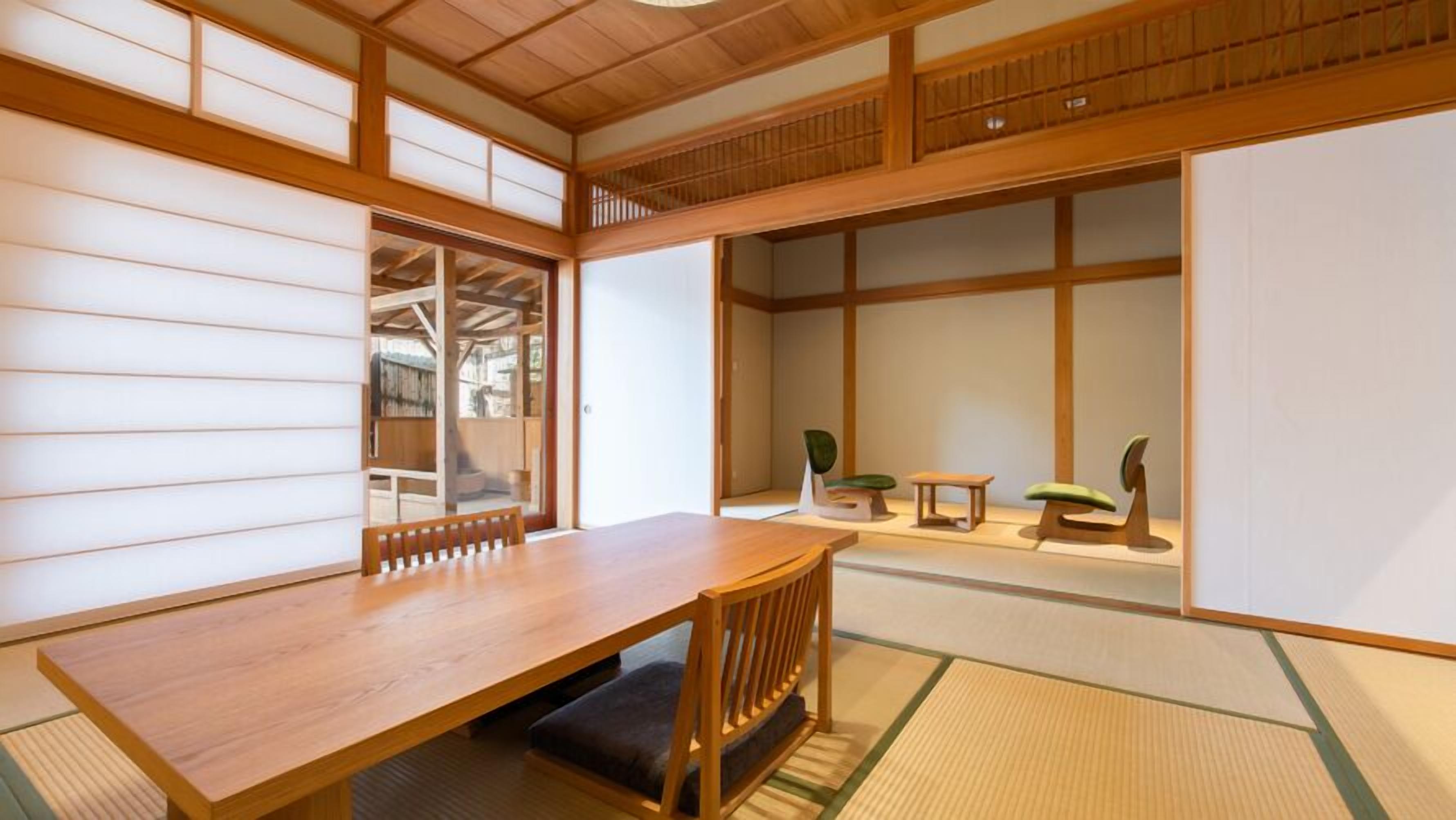 A traditional Japanese room with tatami flooring, a wooden table, and a low bench.