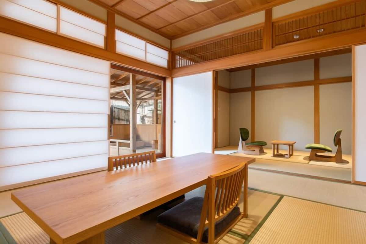 A traditional Japanese room with tatami flooring, a wooden table, and a low bench.