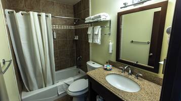 A bathroom with a bathtub, toilet, sink, and a mirror.