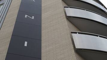 Un edificio de diseño moderno, con un llamativo letrero vertical que incluye letras y números.