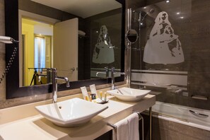 A bathroom with two sinks, a large mirror, and a shower. - Hotel Meninas (Madrid)