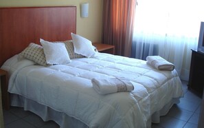 Desk, iron/ironing board, bed sheets