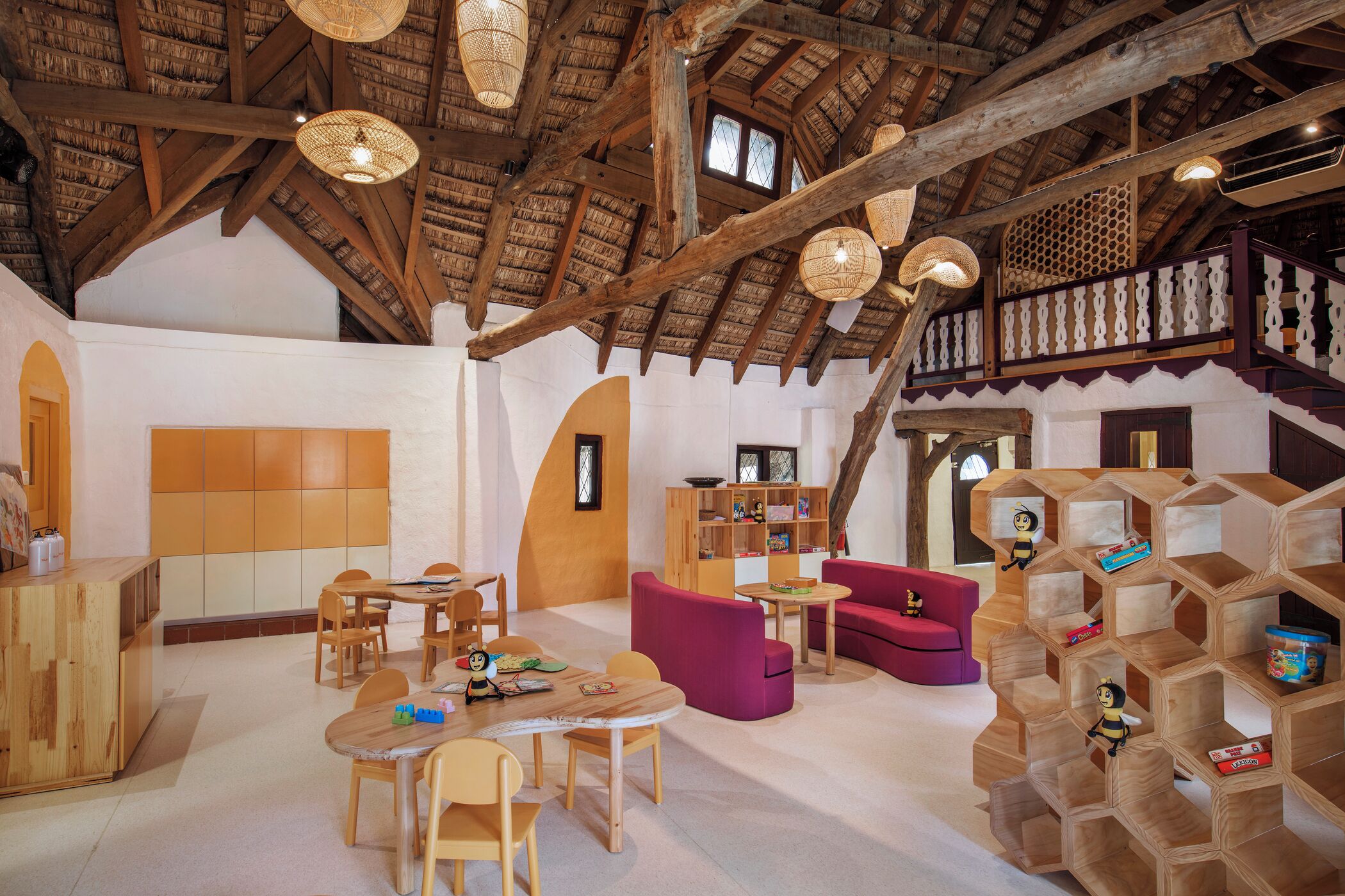 A spacious room with wooden furniture, a high ceiling with exposed beams, and a unique hexagonal shelving unit.