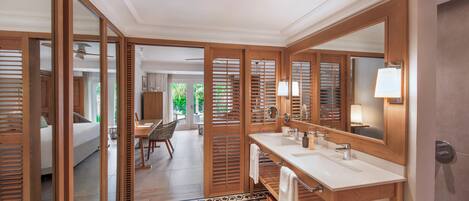 Un baño moderno con un espejo grande, dos lavamanos y detalles de madera.