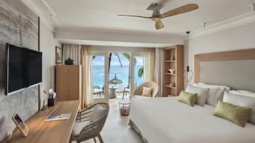 Ein Hotelzimmer mit Bett, Schreibtisch, Computer, Fernseher und Blick auf den Ozean.