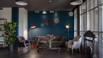 Una sala de estar moderna con una pared azul de acento, un sofá de cuero y una mesa de centro con un jarrón de flores.