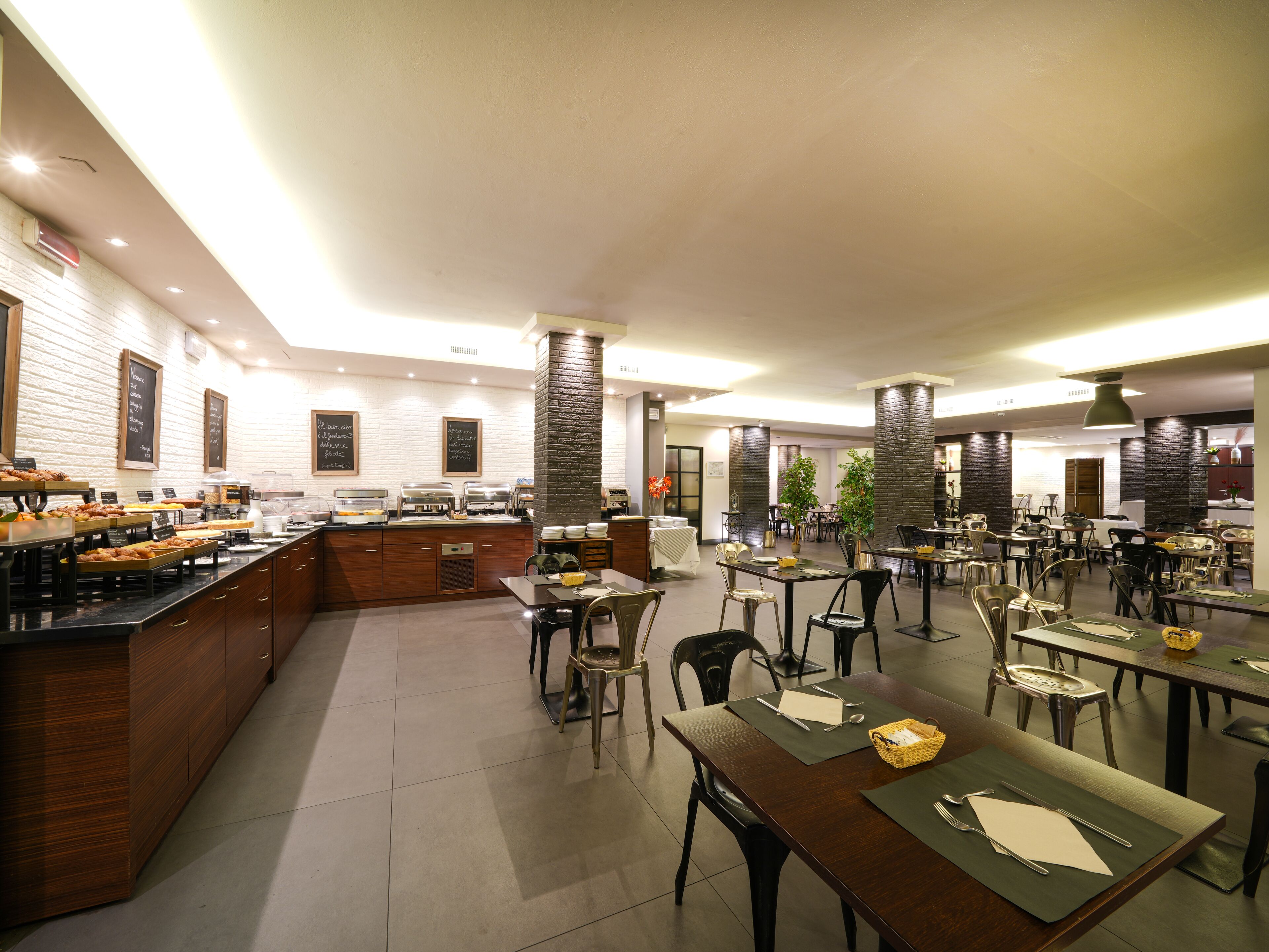 Uma área de refeições moderna com buffet, várias mesas e cadeiras.