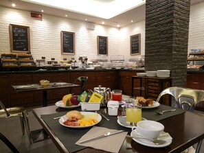 A breakfast buffet with various food items and a coffee station. - La Meridiana Bleisure Hotel (Perugia)