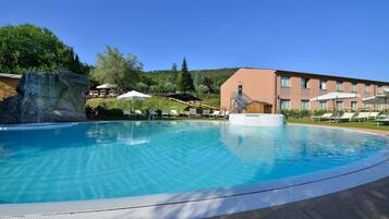 Relax by the serene pool surrounded by lush greenery and comfortable lounge chairs.