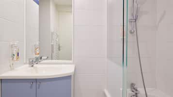 A bathroom with a sink, mirror, and shower.