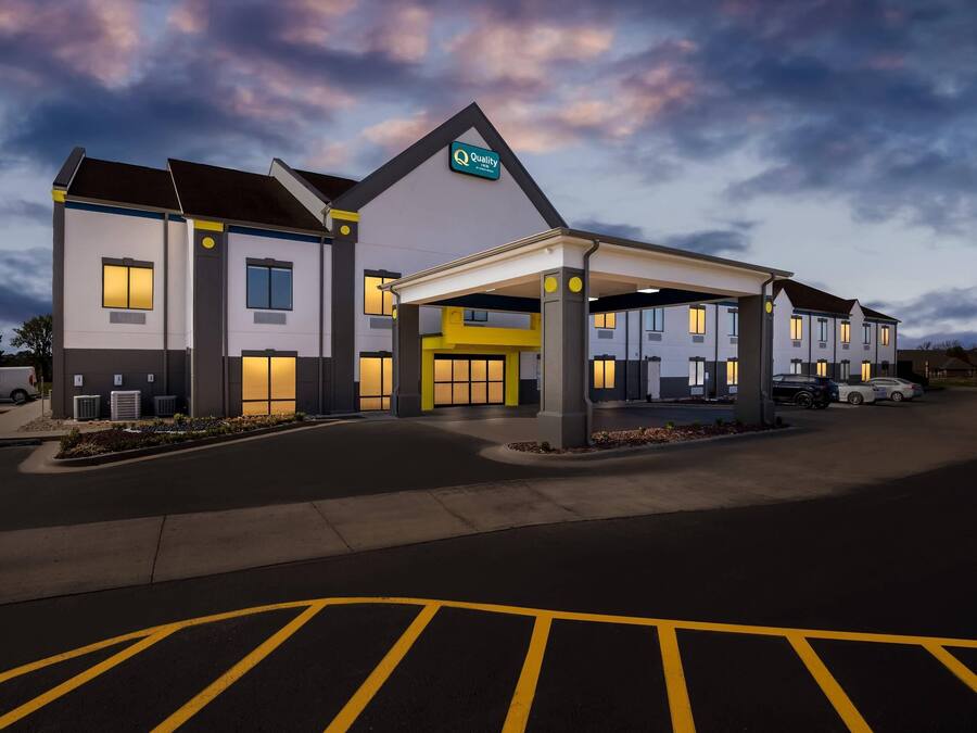 A hotel with a covered entrance, multiple windows, and a sign indicating it is a Quality Inn.