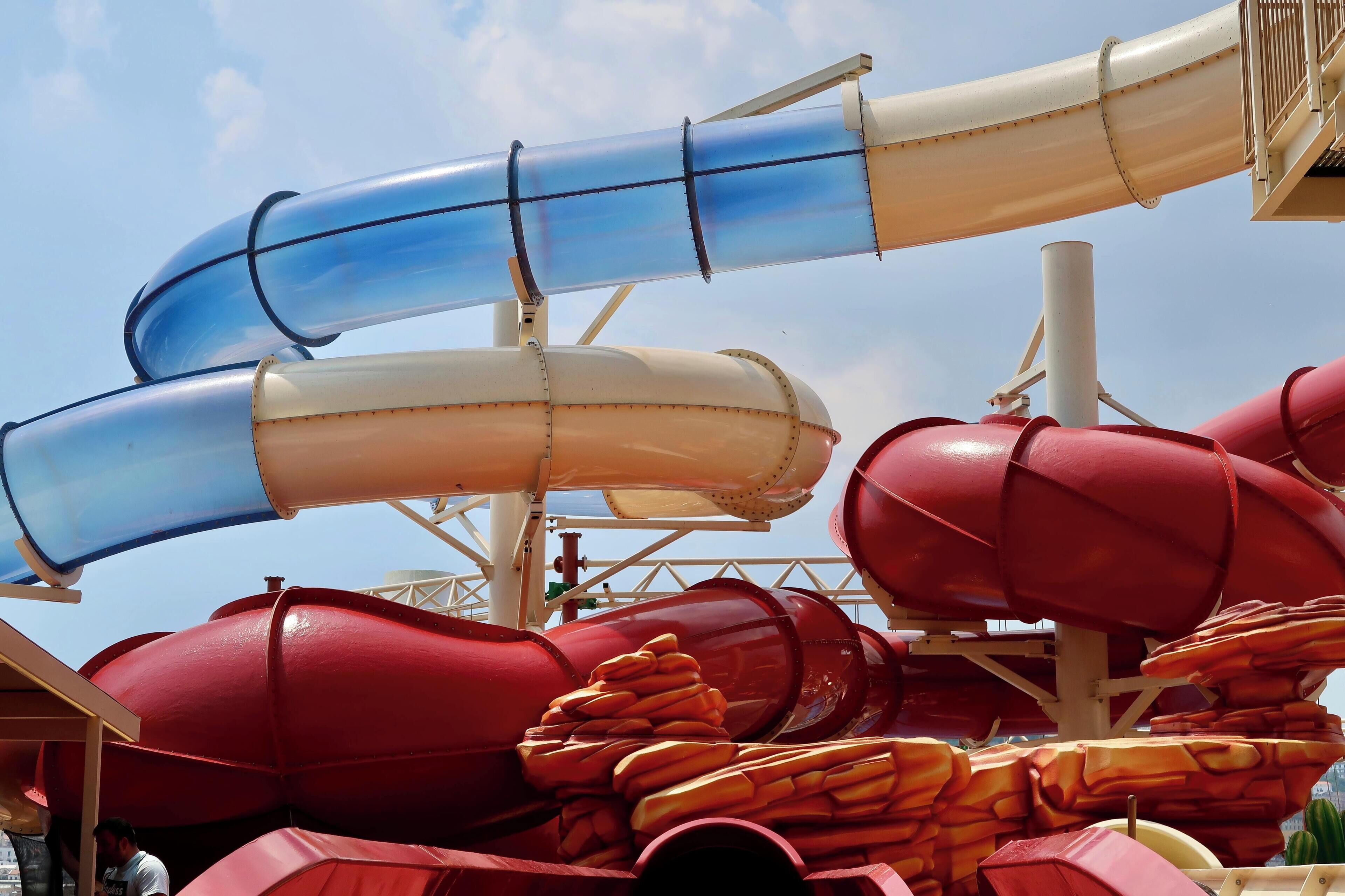 Een waterparkattractie met verschillende glijbanen in blauw en rood.