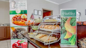 Um buffet de café da manhã com diversos alimentos e um aviso promovendo um estilo de vida saudável.