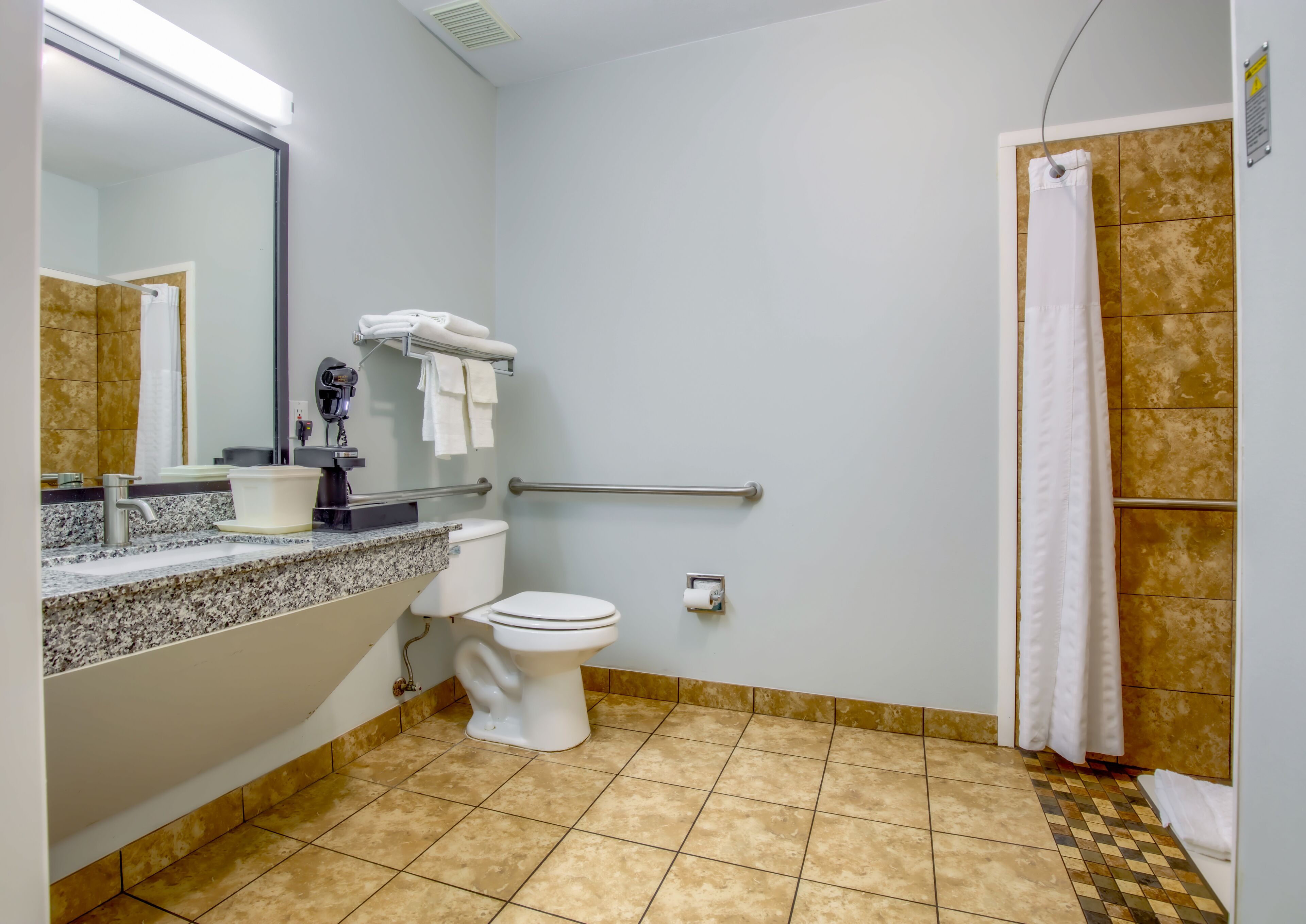 A bathroom with a sink, toilet, and shower.
