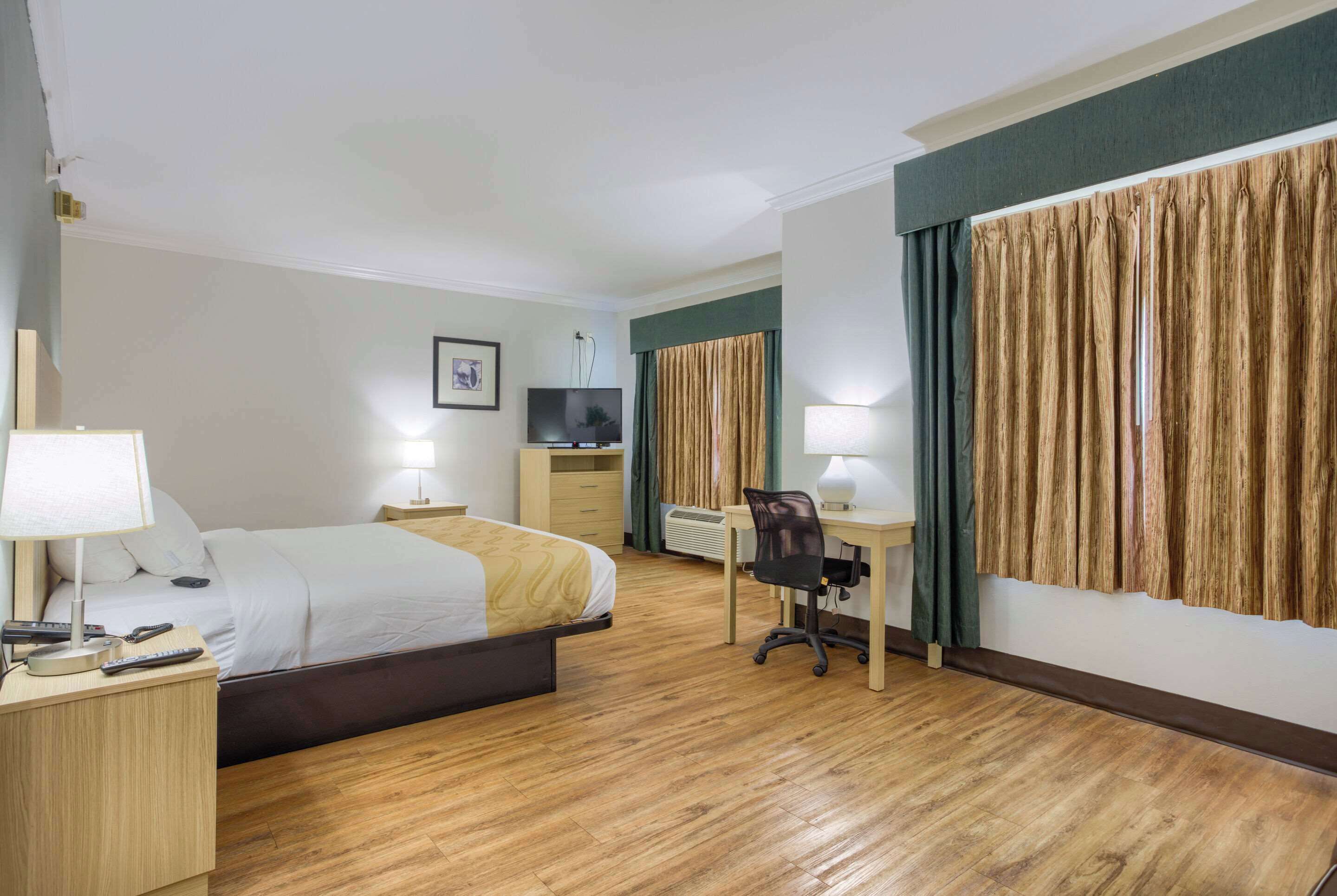 Une chambre d’hôtel équipée d’un lit, d’un bureau, d’une chaise et d’un téléviseur.