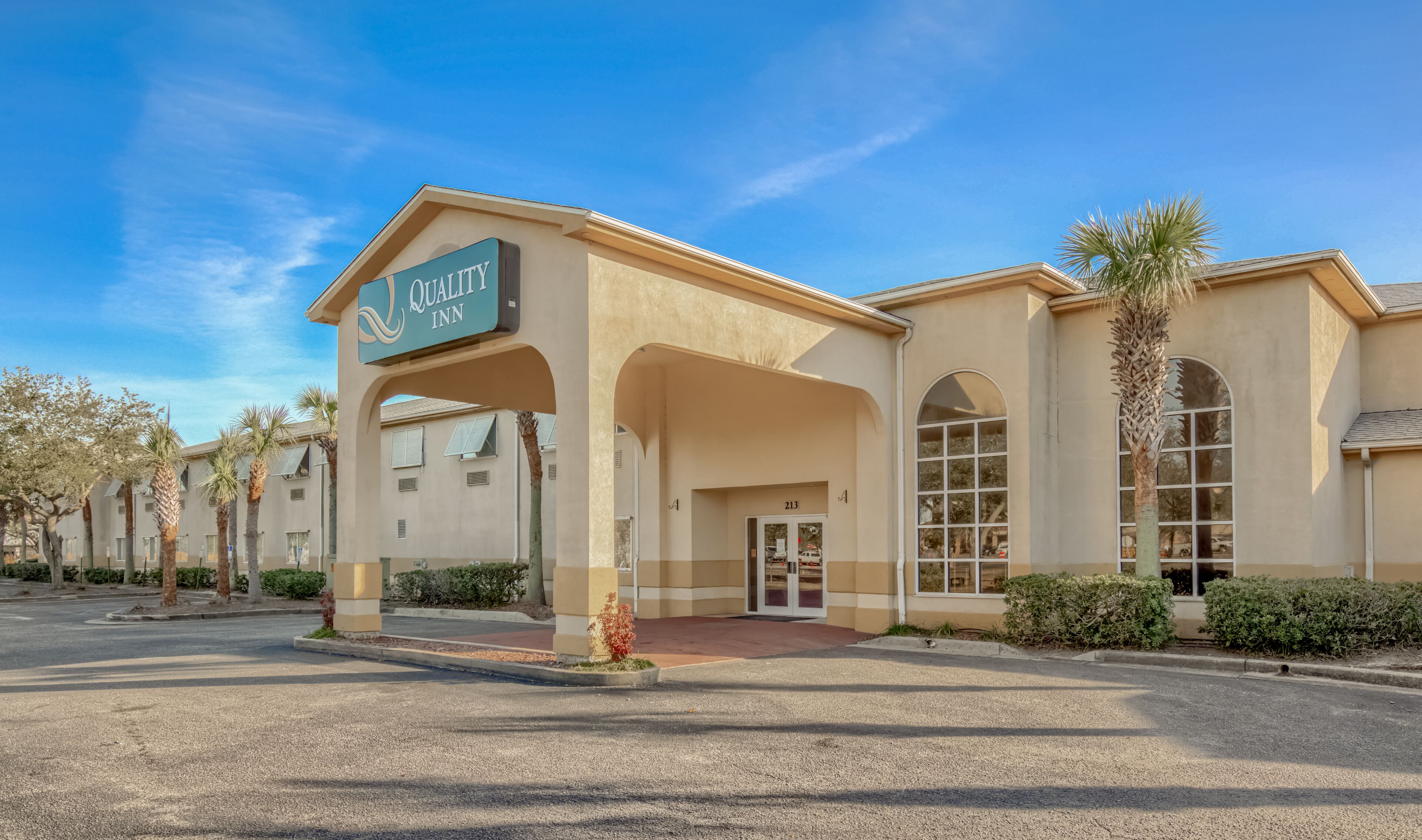 A hotel with a sign reading "Quality Inn" and a large arched entrance.