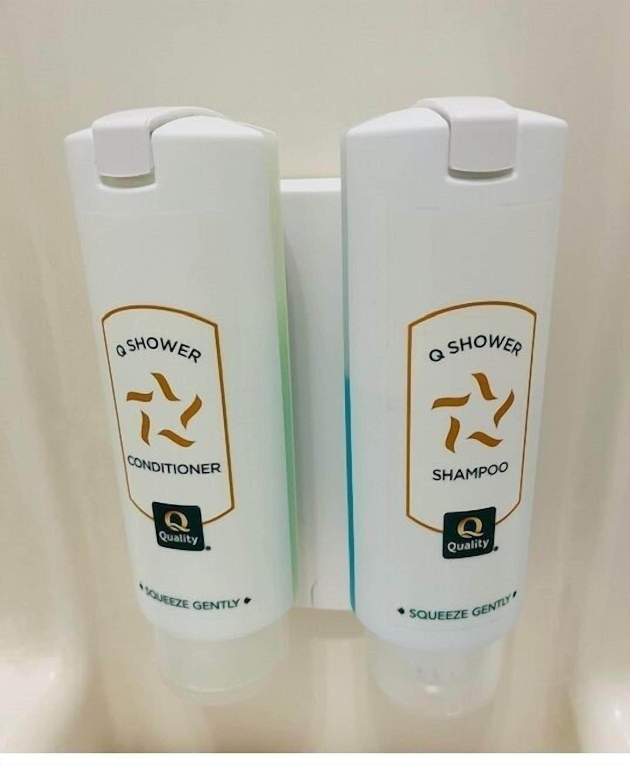 Two bottles of Q Shower conditioner and shampoo in a bathroom.