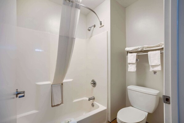 A bathroom with a shower, toilet, and towel rack.