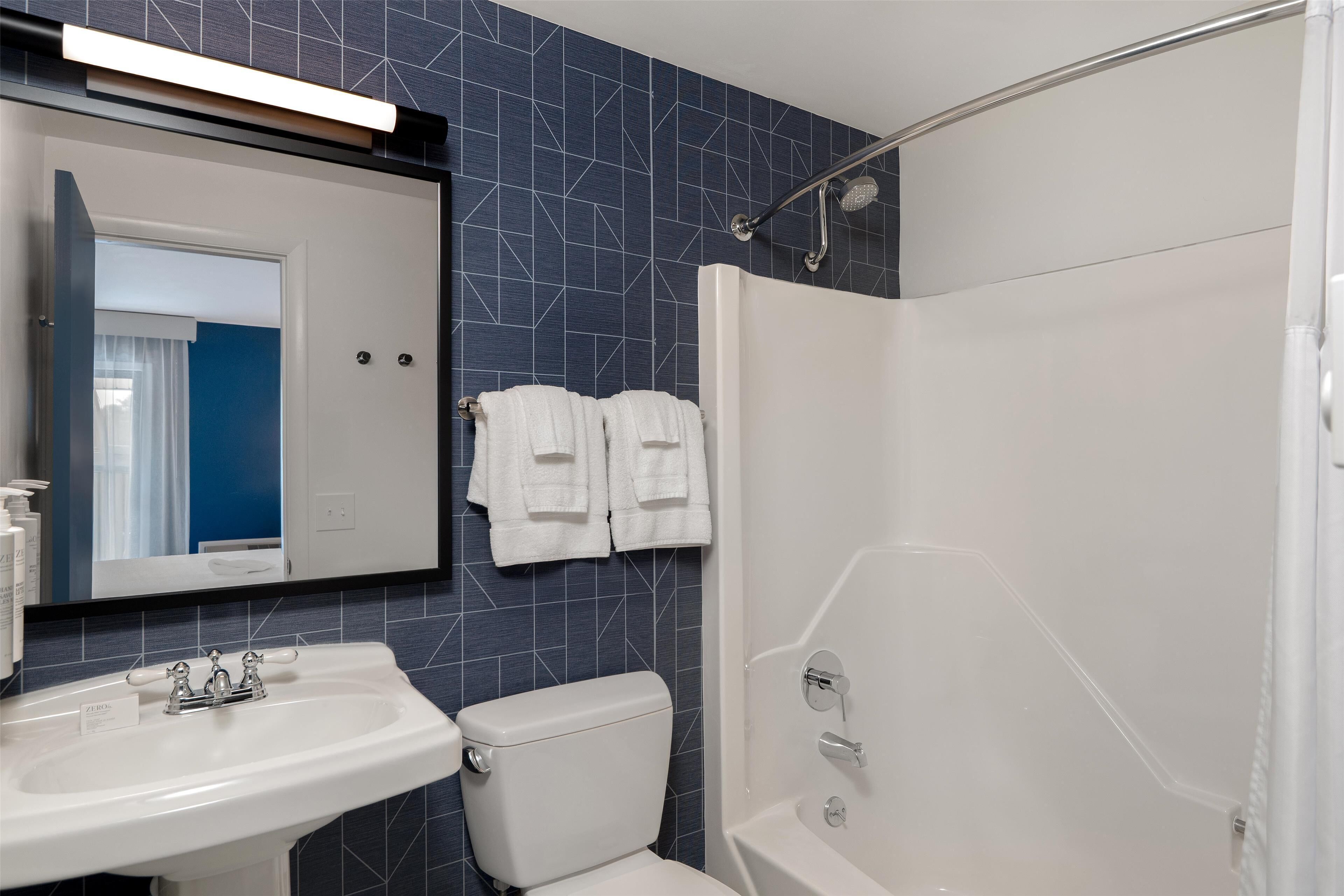 A bathroom with a white sink, a toilet, a shower with a glass door, and a mirror above the sink.