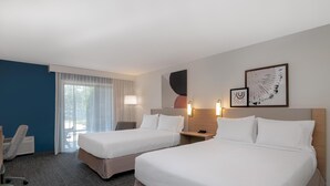 A hotel room with two beds, a desk, a chair, and a window with curtains. - Spark by Hilton Chincoteague Island (Chincoteague)