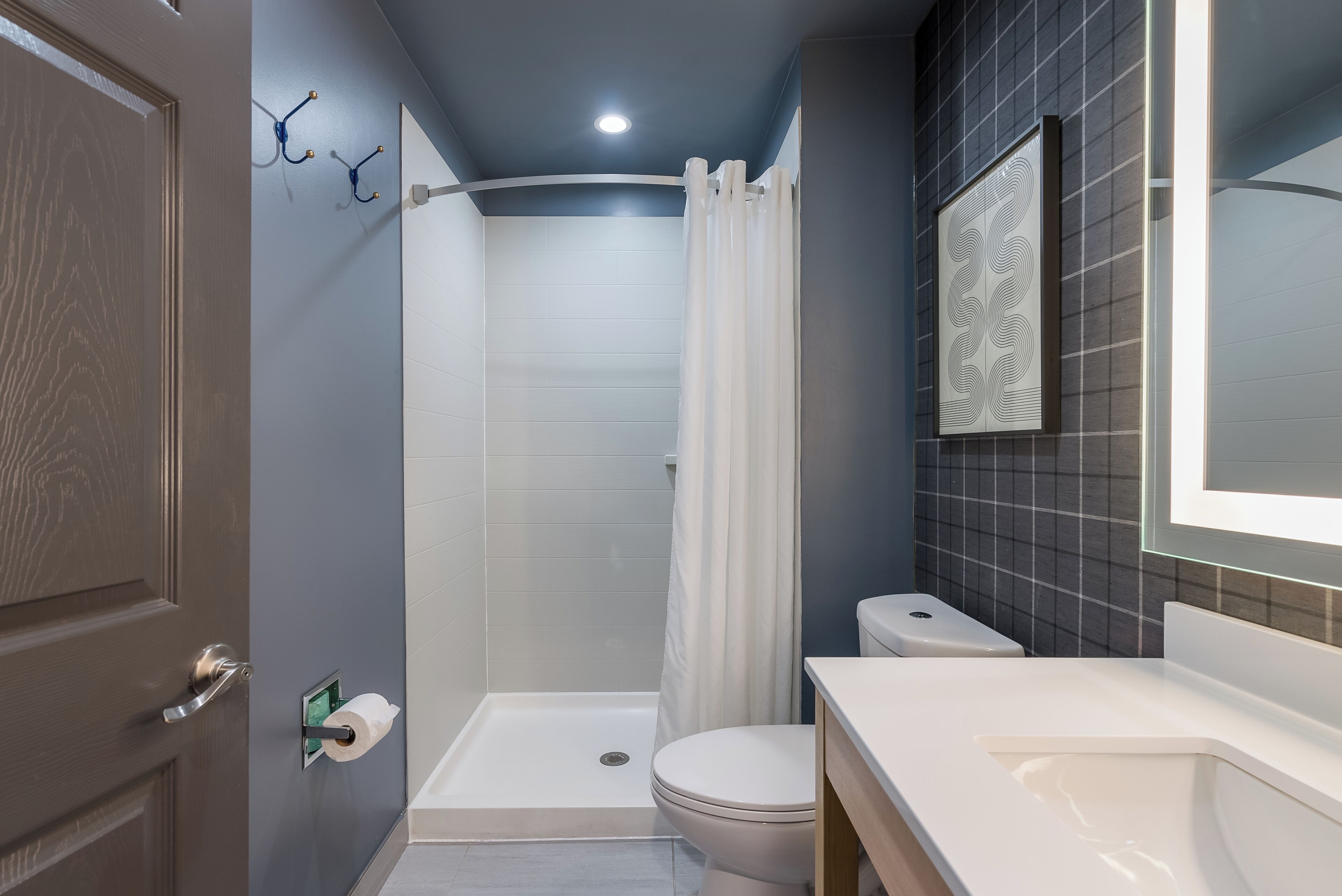 A modern bathroom with a shower, toilet, and sink.