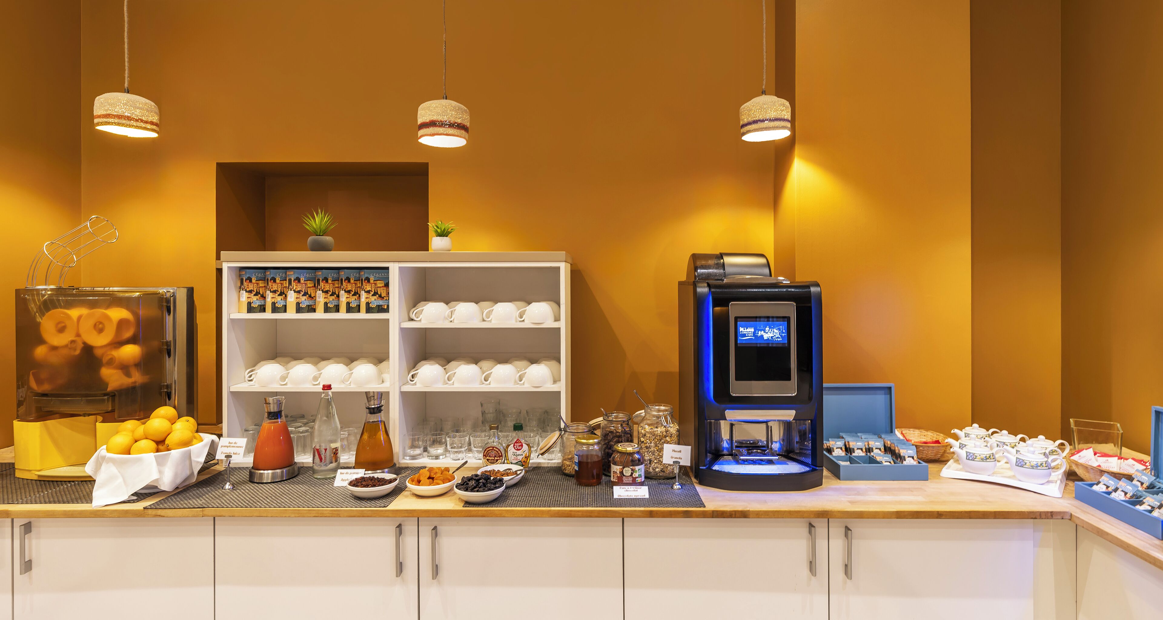 A breakfast bar with a coffee machine, a fruit bowl, and a variety of breakfast items.