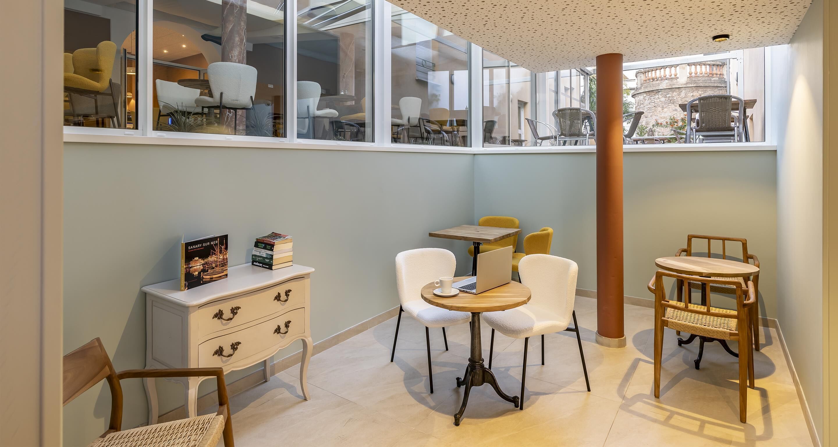 A cozy cafe with a white cabinet, a wooden table, and chairs.