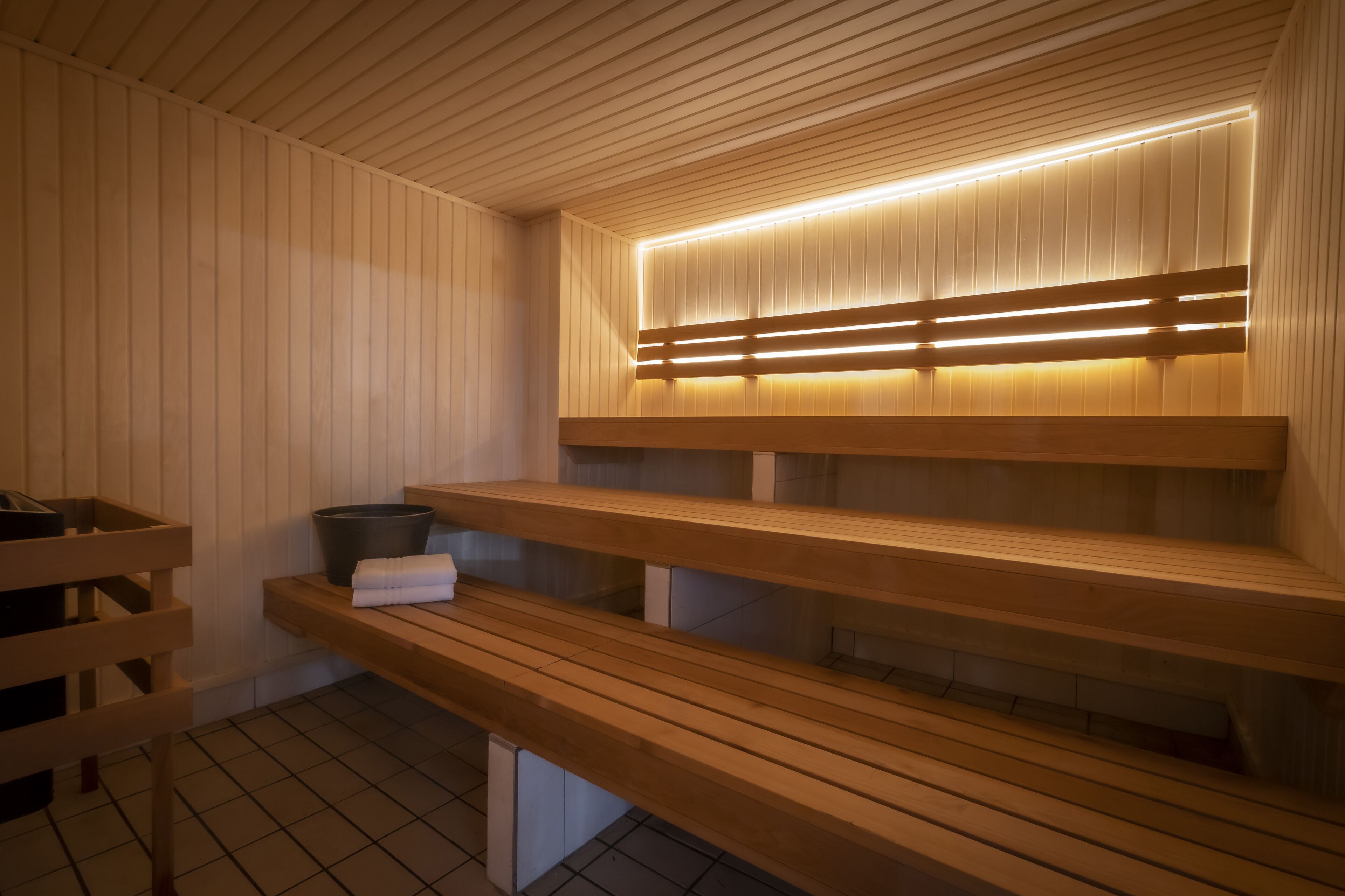 A sauna with wooden benches and a sloped ceiling.