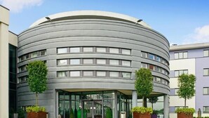 Un edificio moderno con fachada curva, ventanas amplias y entrada de vidrio.