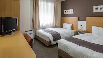 Habitación de hotel con dos camas, un escritorio, un televisor y una ventana con cortinas.
