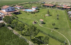 A residential area with multiple houses, a swimming pool, and well-maintained lawns. - Fattoria Maremmana (Grosseto)