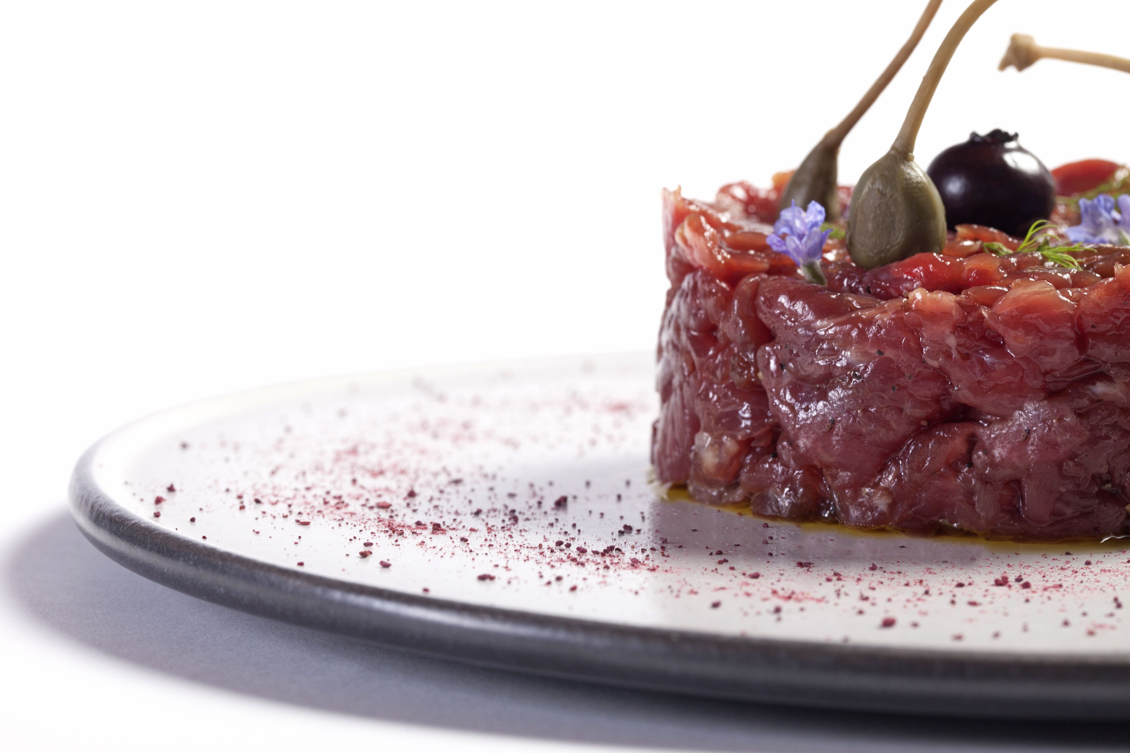 A plate of raw tuna tartare with garnishes.