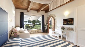 Un dormitorio con una cama grande, un escritorio y vistas al exterior.