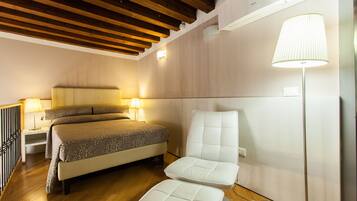 Un dormitorio con cama, lámparas de noche, una silla y una lámpara de pie.