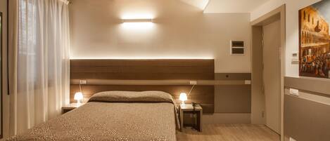 A bedroom with a large bed, bedside lamps, a wooden ceiling, and a painting on the wall.
