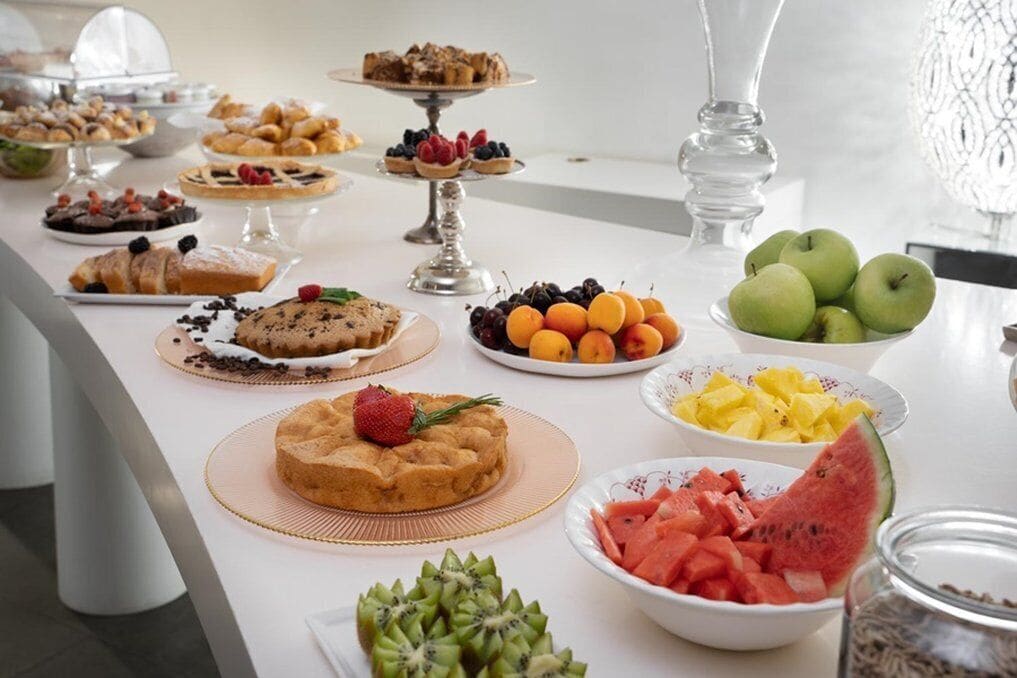 Una mesa de buffet con diversos postres y frutas.