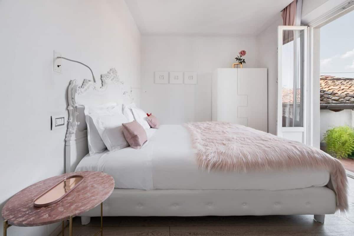 A bedroom with a bed, a small round table, and a cabinet.