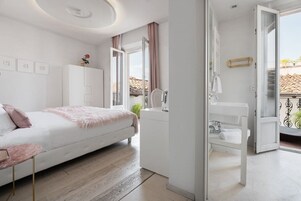 Una camera da letto moderna con un letto, comodino, armadio e bagno con lavandino e doccia.