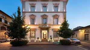 A multi-story building with a grand entrance, large windows, and a well-lit facade.