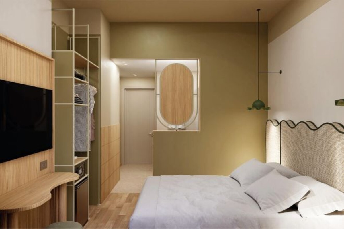Un dormitorio moderno con una cama, un televisor, un armario y un espejo.