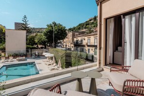 A poolside area with lounge chairs and a clear view of the surrounding buildings. - Modica Inn Centro, BW Premier Collection (Modica)